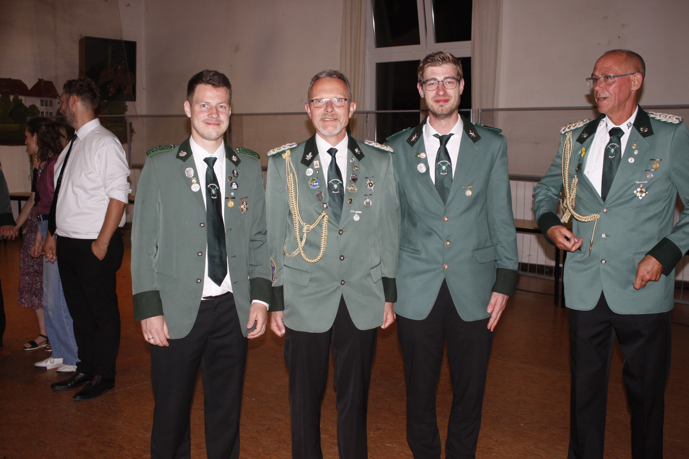 Vier Männer in grünen Uniformen stehen nebeneinander